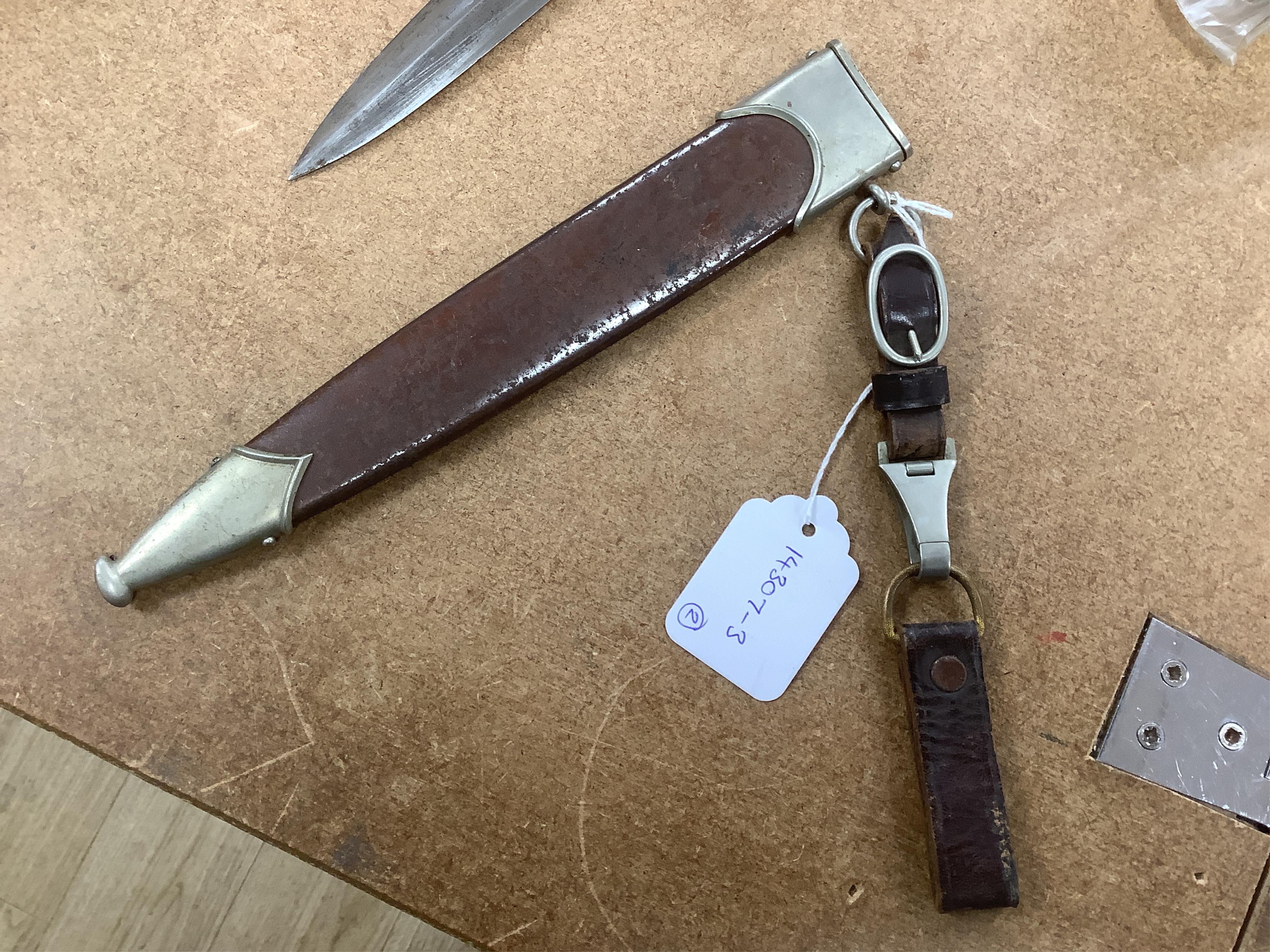 A WWII German SA dagger, regulation pattern in its steel scabbard with regulation nickel mounts, and leather hanging band and a German dress bayonet by Paul Seilheimer. Condition - fair, some wear